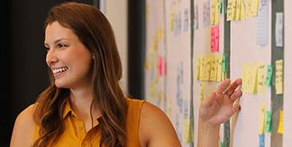 A woman speaking in front of a project plan